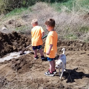 Noah helping dig out the mud around the leak